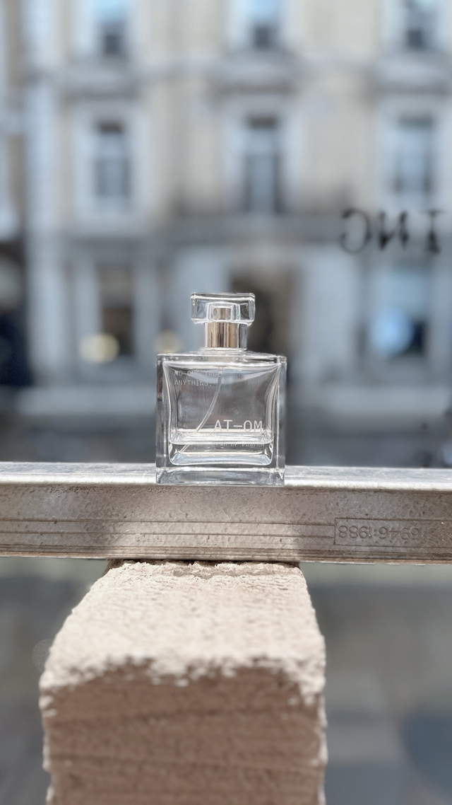 image of no one true anything atom eau de parfum fragrance.  DESIGNED TO MELT INTO THE WEARER'S NATURAL PHEROMONES, AT-OM IS A LIGHTWEIGHT HYPER-MODERN UNI SEX EAU DE PARFUM FRAGRANCE, EMPLOYING FRESH + NATURAL COMPONENTS. FRAGRANCE NOTES: TOP: LEMON ZEST + PINK PEPPER MIDDLE: IRIS + VIOLET BASE: SOFT WOODY MUSK INGREDIENTS: PARFUM, ETHANOL. EAU DE PARFUM NATURAL SPRAY 100ML BOTTLE. HAND-POURED IN THE UK.